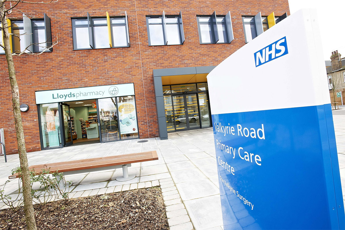 Close Up Of Nhs Sign With Pharmacy In Background
