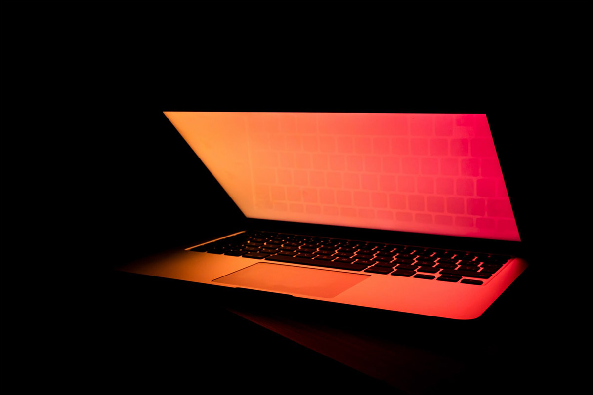 Laptop With Red Hue On Dark Background