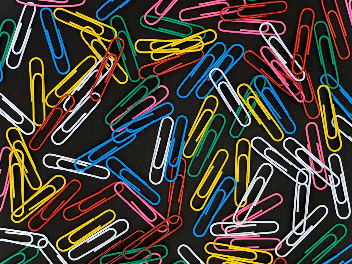 Multicoloured paper clips on a black background